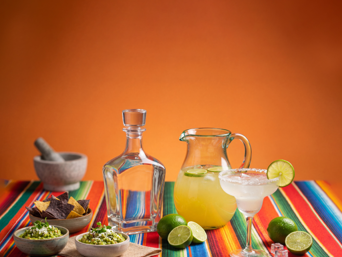 A bottle of tequila and a pitcher of margaritas